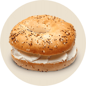 An everything bagel cut in half with cream cheese in the middle.