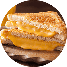 A grilled cheese on toasted white bread, cut in half and stacked on top of one another with gooey American cheese.