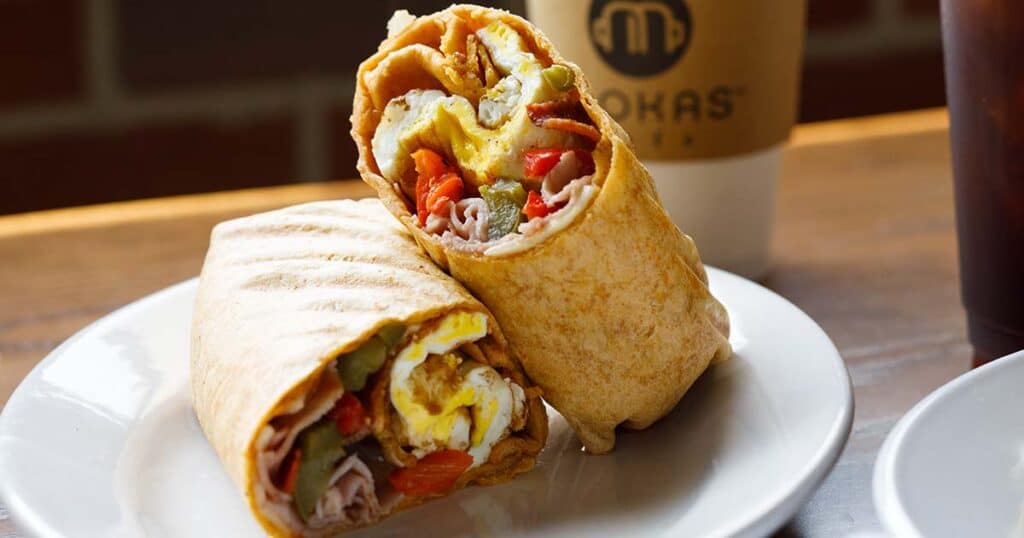 Catering breakfast burrito wrap being served on a white plate